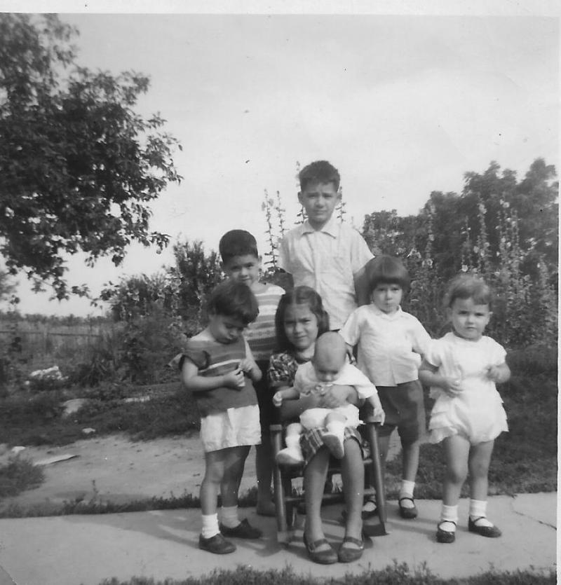Toler Kids: Kyle and Keith standing in back, Erma sitting in chair holding Kevin, Rita lookingdown, Tona with her hand on the chair, Sherry standing in front